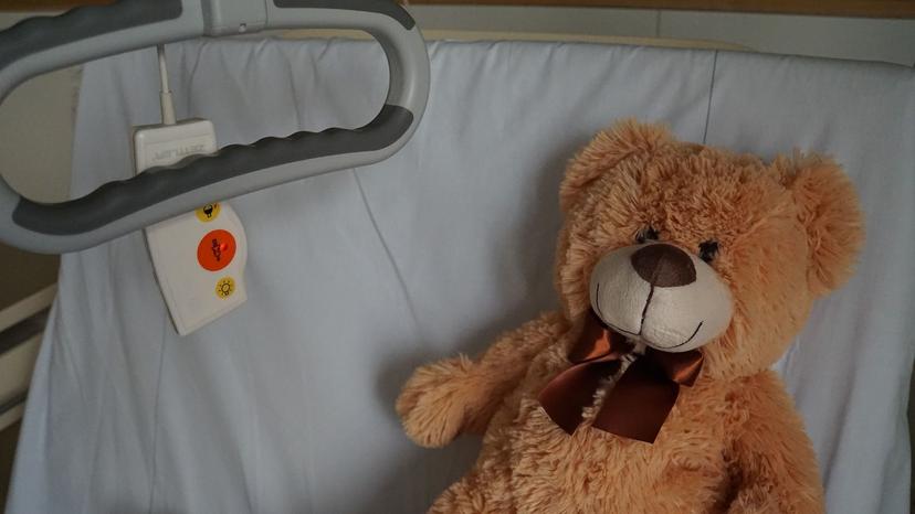 عروسک خرس قهوه‌ای روی تخت بیمارستان